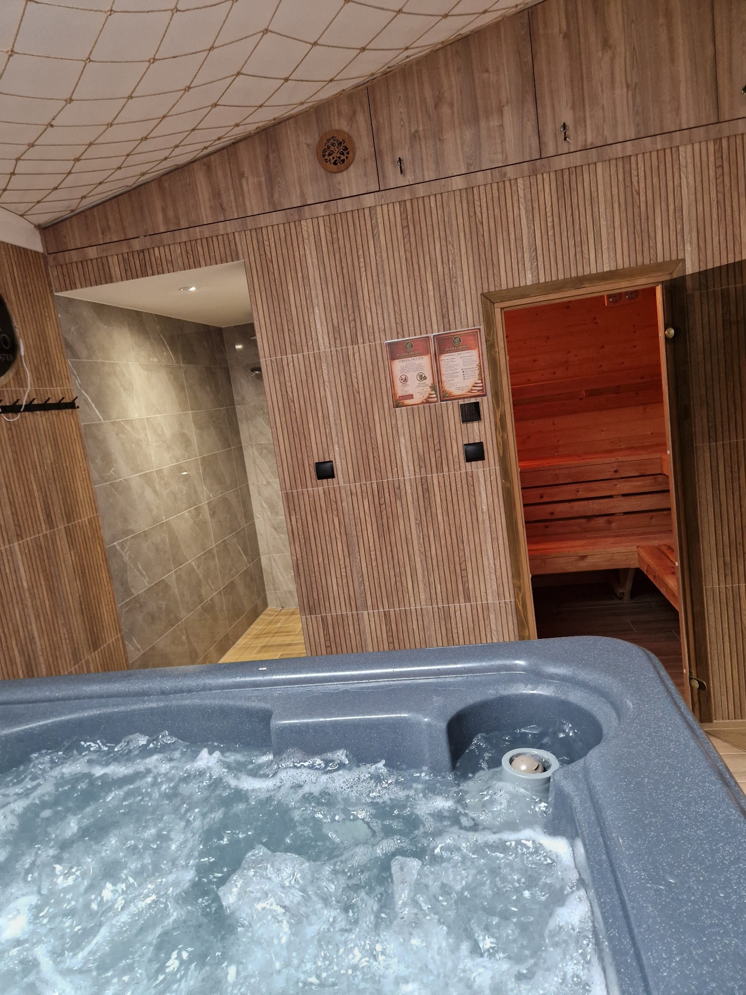 Jacuzzi, prysznic i wejście do sauny w strefie SPA